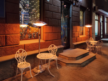 Tables and chairs at entrance to cafe in evening Photographie intitulée "Tables and chairs a…" par Art$Art, Œuvre d'art originale, Photographie numérique