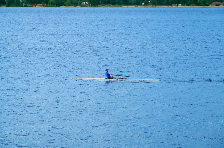 Sportsman on a single boat during a morning workout on the r 摄影