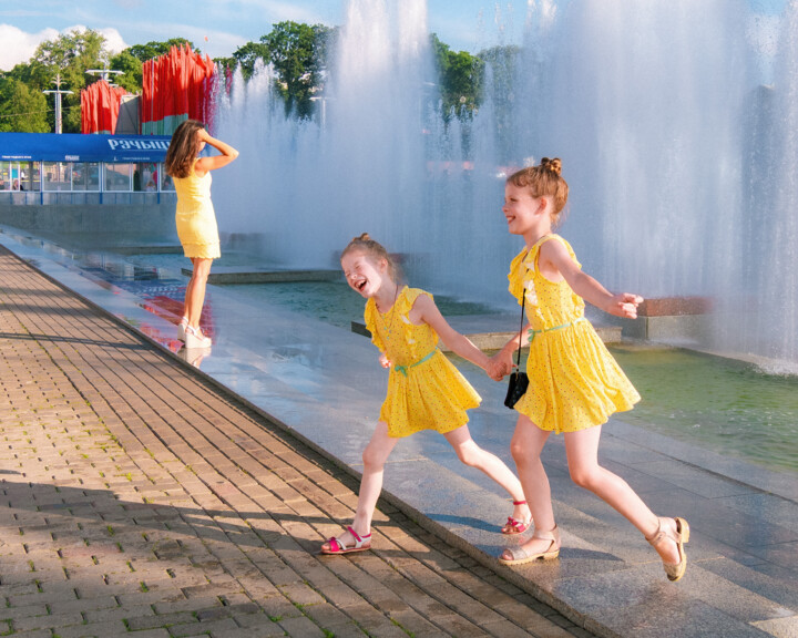 “Summer in Yellow: Joy Under the Fountain’s Spray” Fotografia